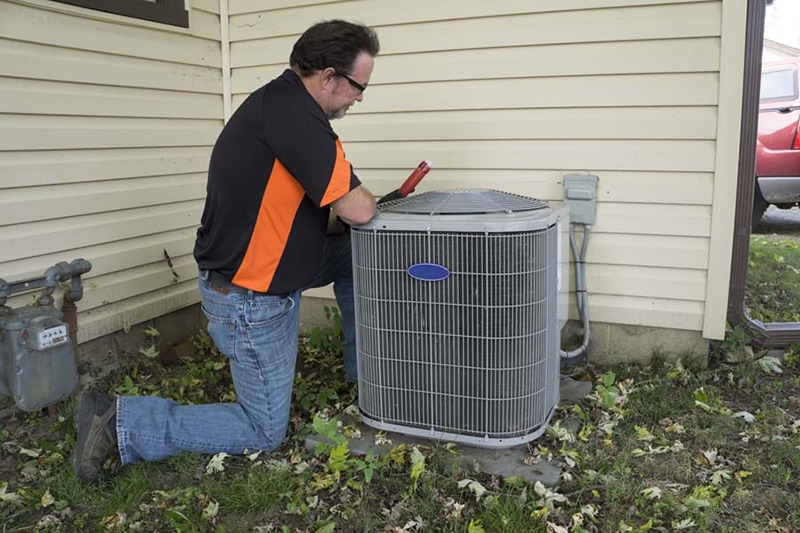 AC repair technician working on air conditioning unit.