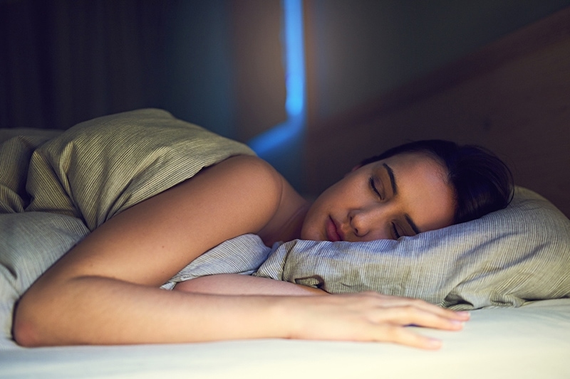 Shot of a young woman sound asleep in her bedroom ac air conditioning sleeping health benefits