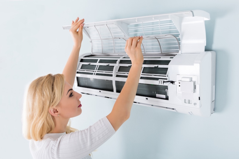 Woman opening ductless system before Scott Brothers technician arrives in Boone, NC.