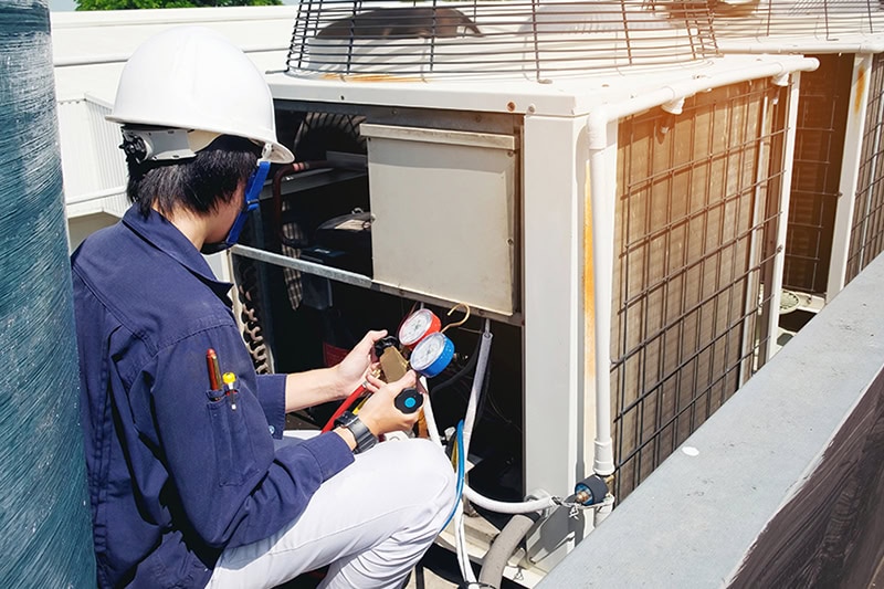 Why Is a Commercial AC Tune-Up Important? A technician fixing HVAC equipment.