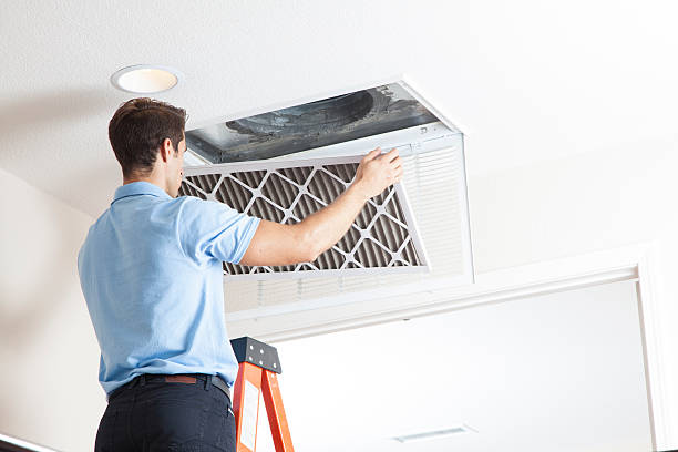 Man cleaning air ducts in home. Furnace Filters 101.